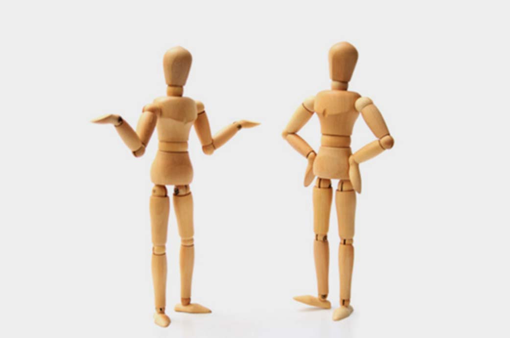 Two wooden marrionettes in different gestures and poses.