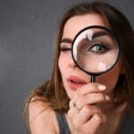 National Arts Fundraising School (NAFS) - 21st May 2025 Arts Fundraising Webinar - photo of woman holding a magnifying glass up to her eye.