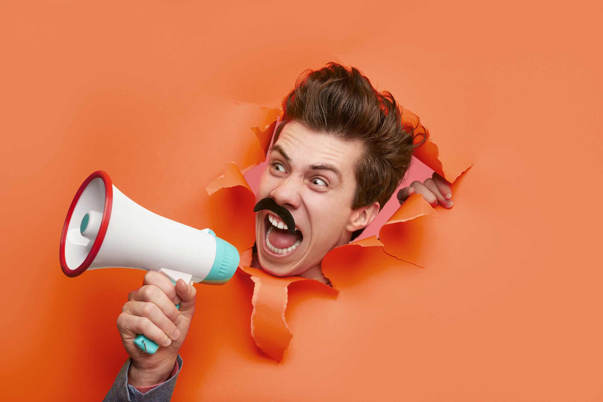 NAFS - Convincing your boss - image of excited man on a megaphone bursting through an orange wall